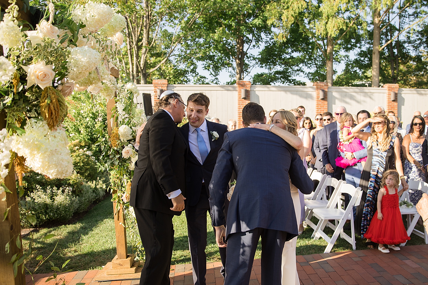 bride hugs sons at top of aisle