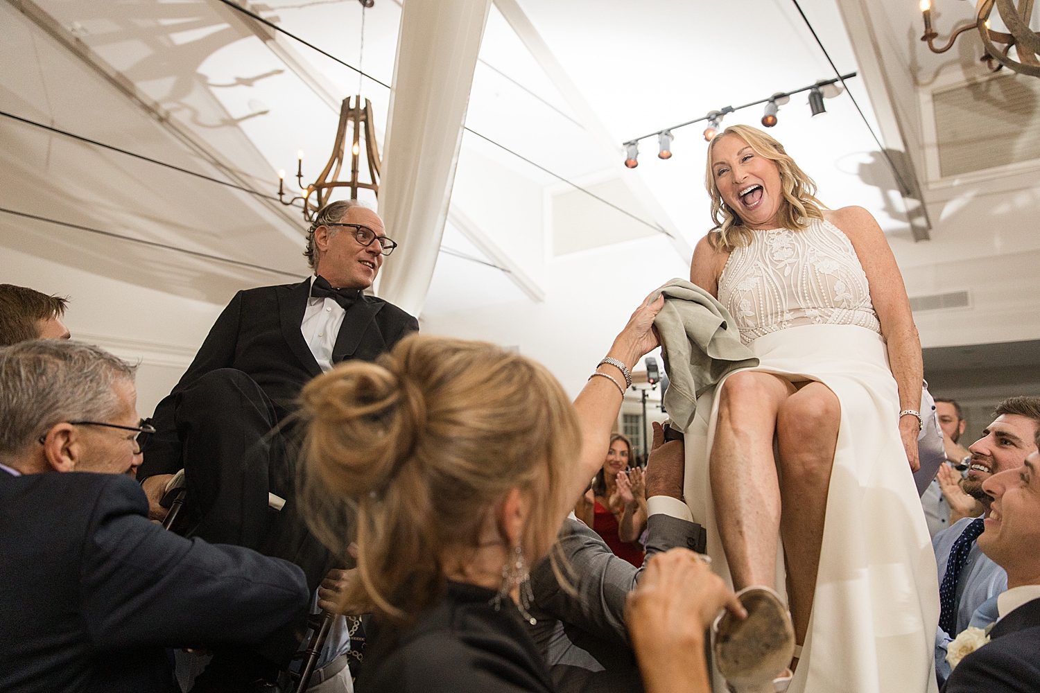 bride and groom lifted in chairs on the dancefloor during horah