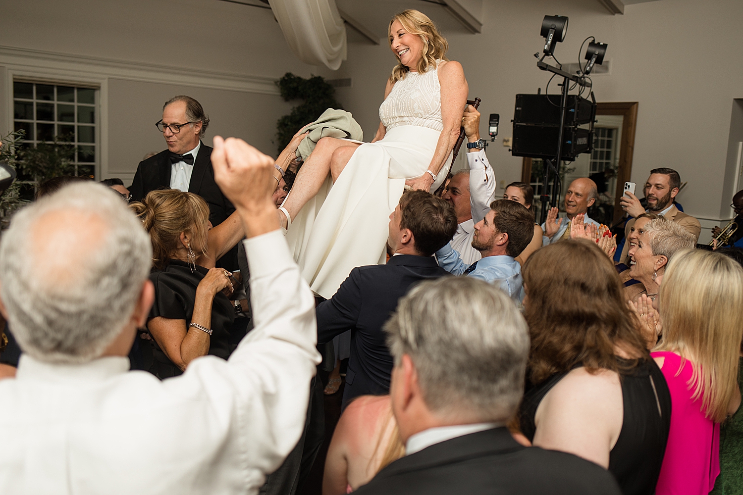 bride and groom lifted in chairs on the dancefloor during horah