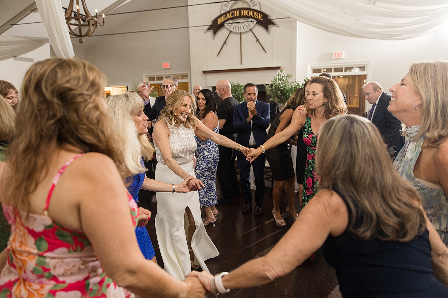 candid wedding guests dancing with bride horah