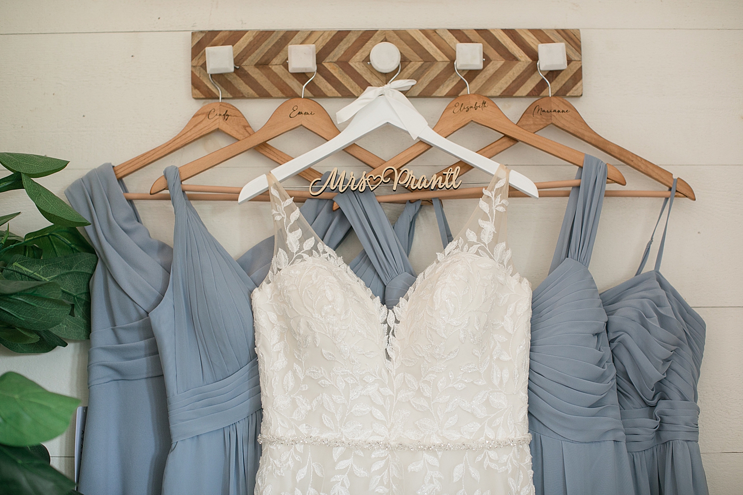 bridal gown hanging with blue bridesmaids dresses