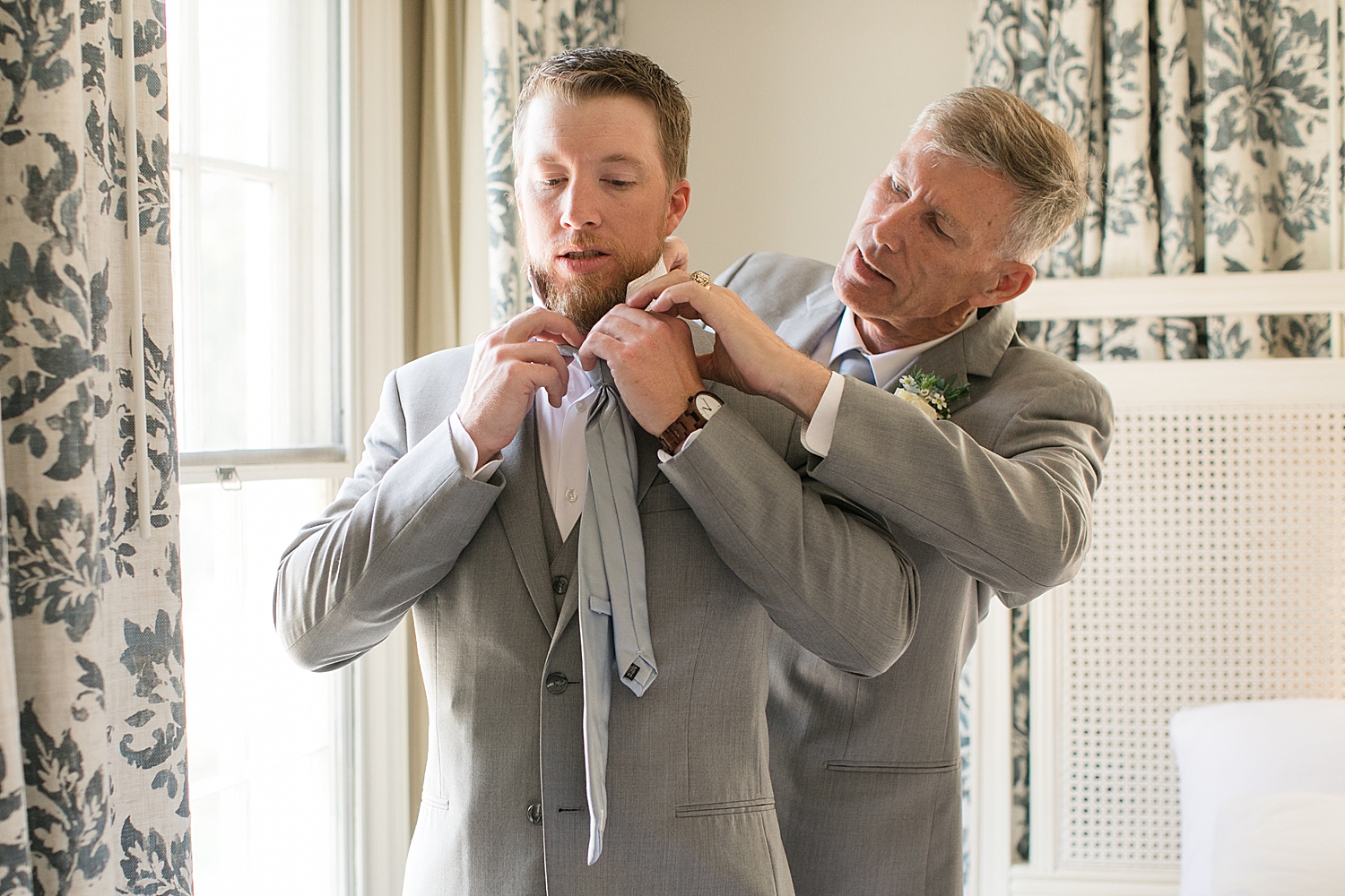 groom's dad helps him put on tie