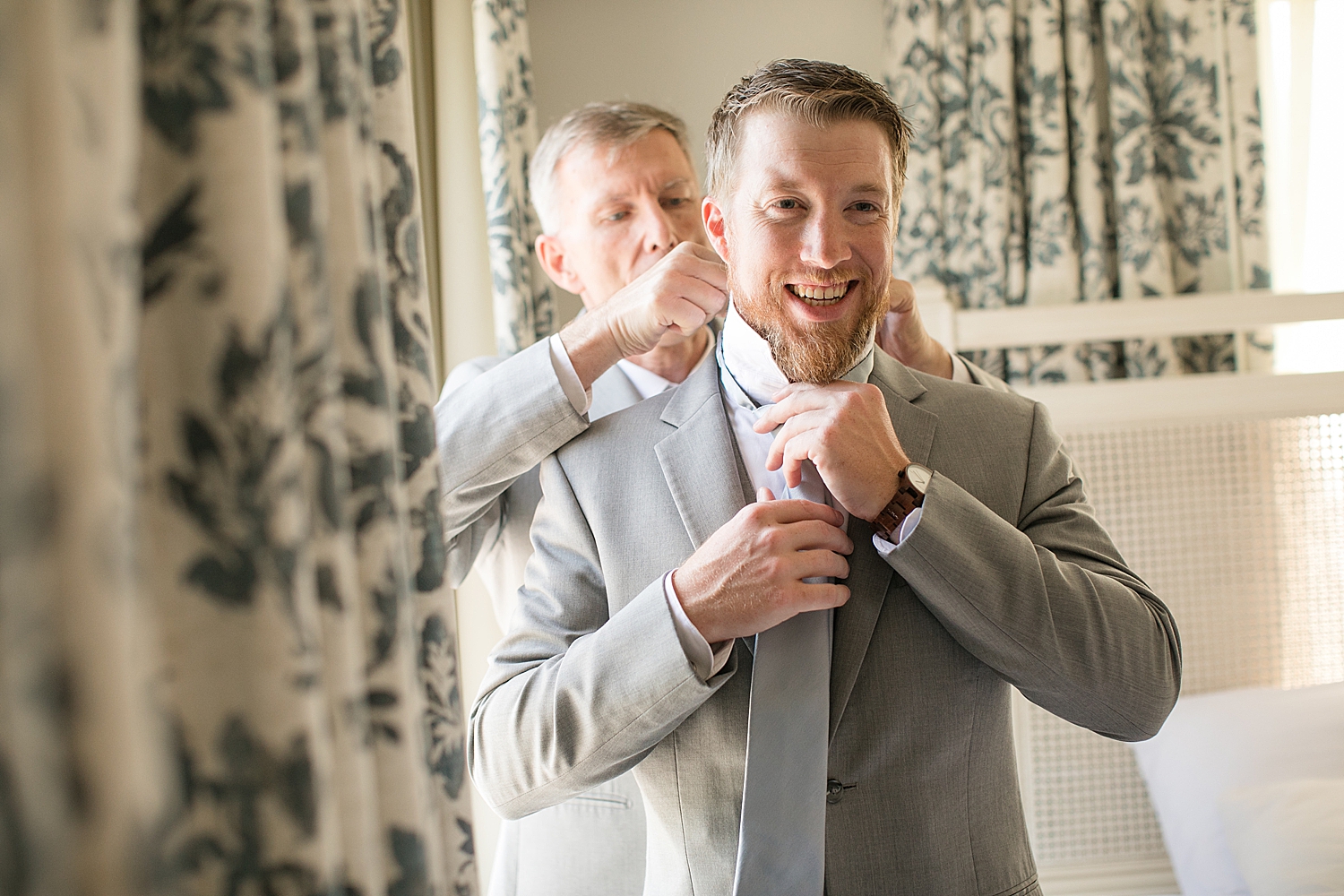 groom's dad helps him put on tie