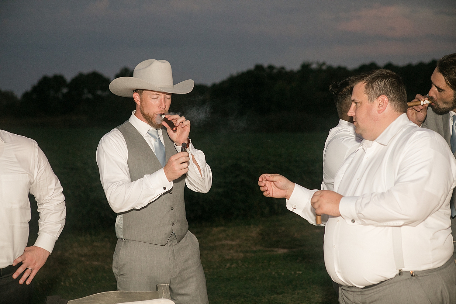 groom smokes cigar with friends