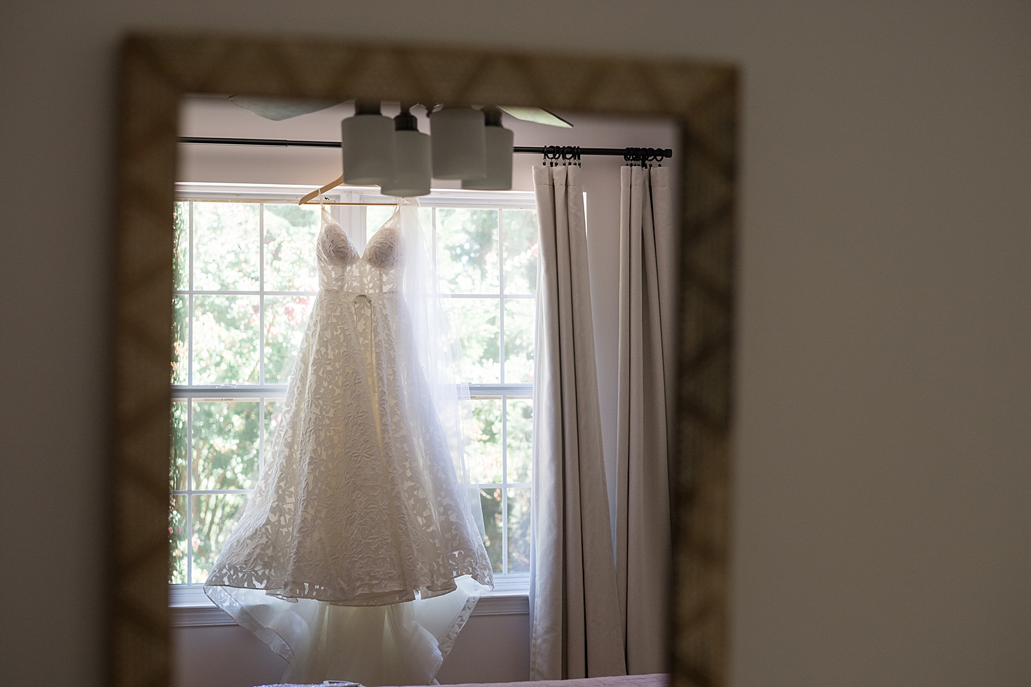 bridal gown hanging from window