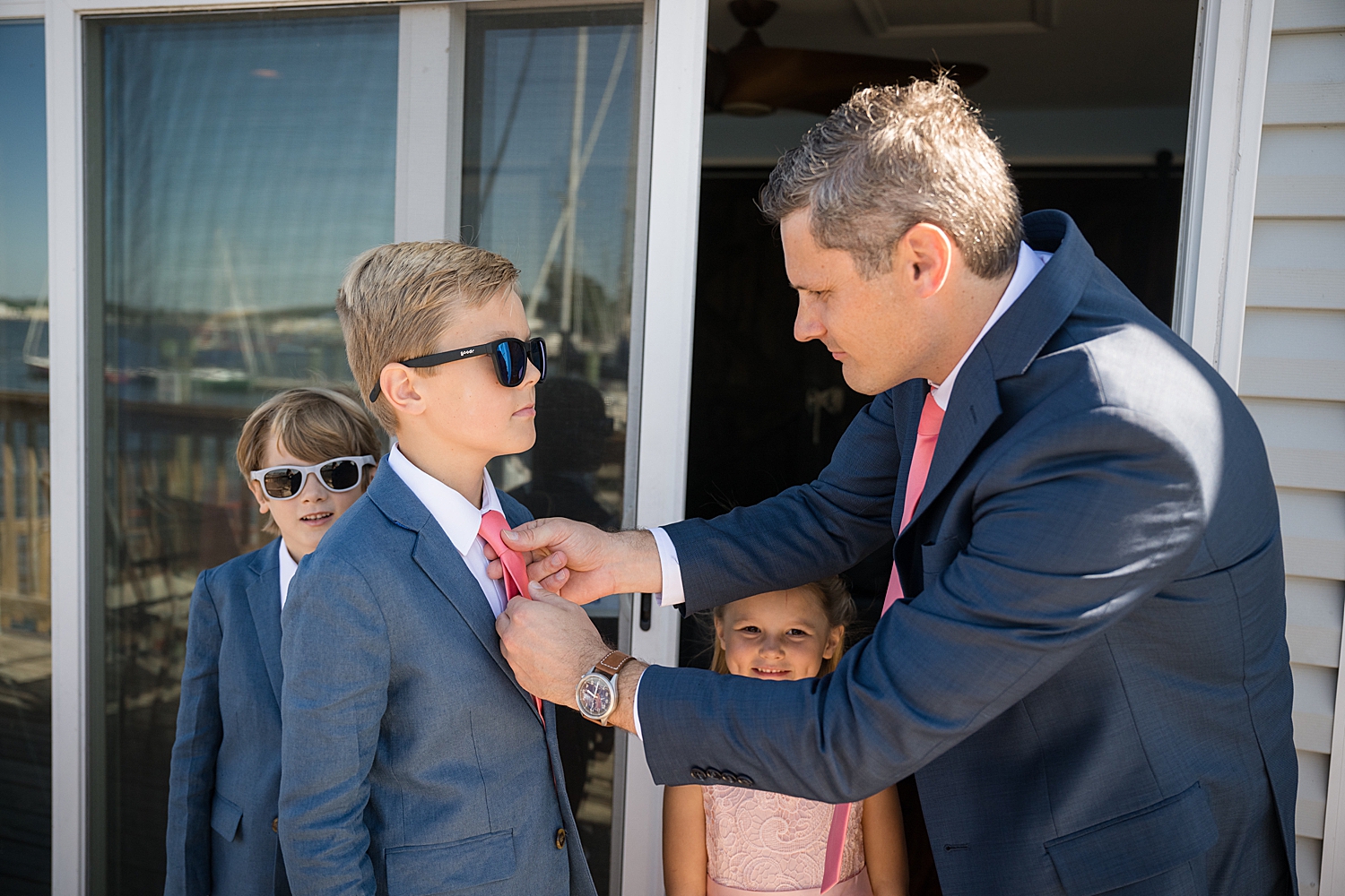 groom helping sons get dressed as his best men