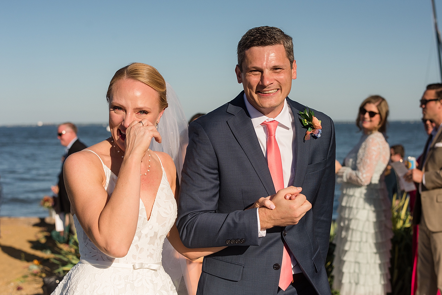 bride and groom happily recess, bride wipes away tear