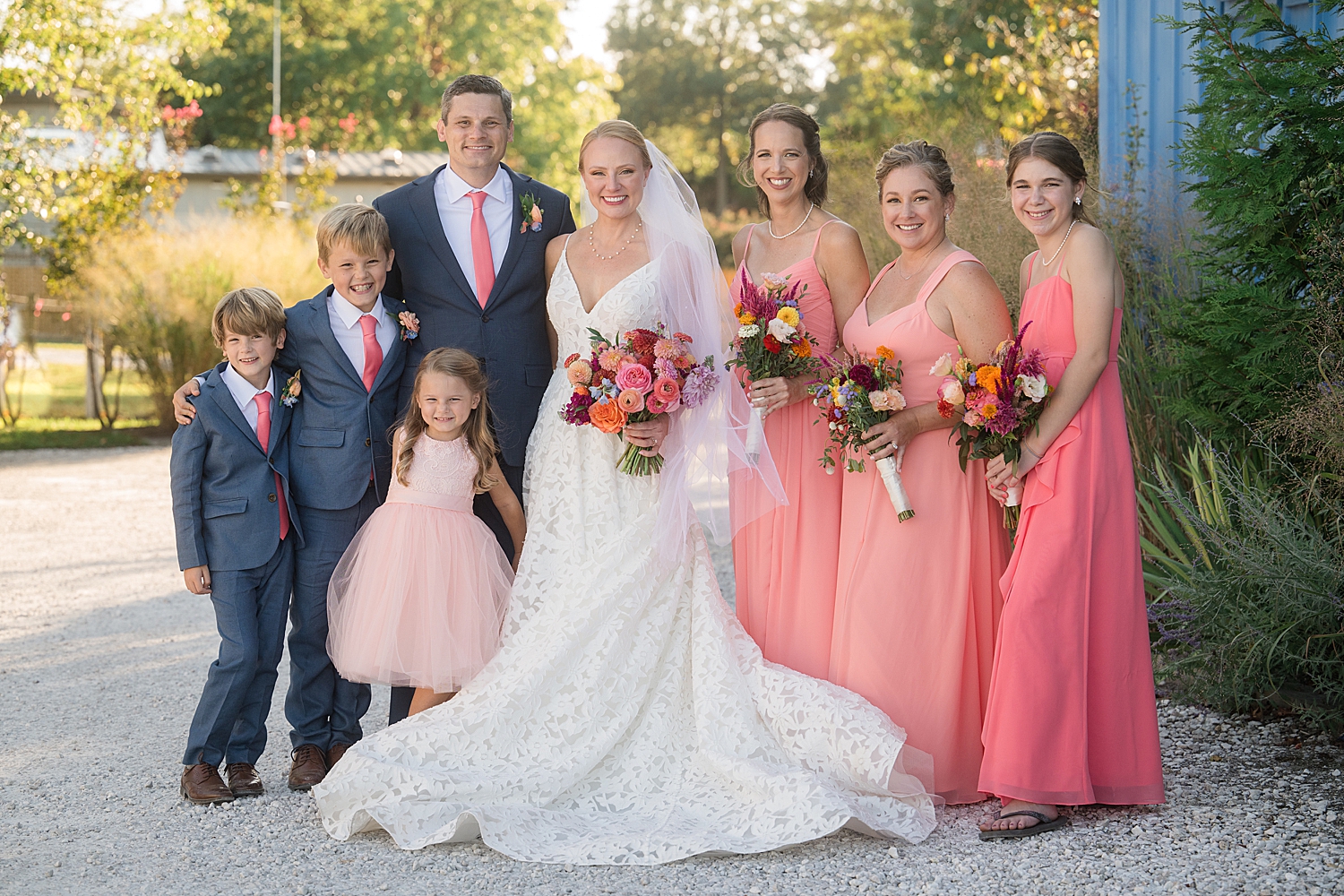 full wedding party portrait, blue suits and pink gowns