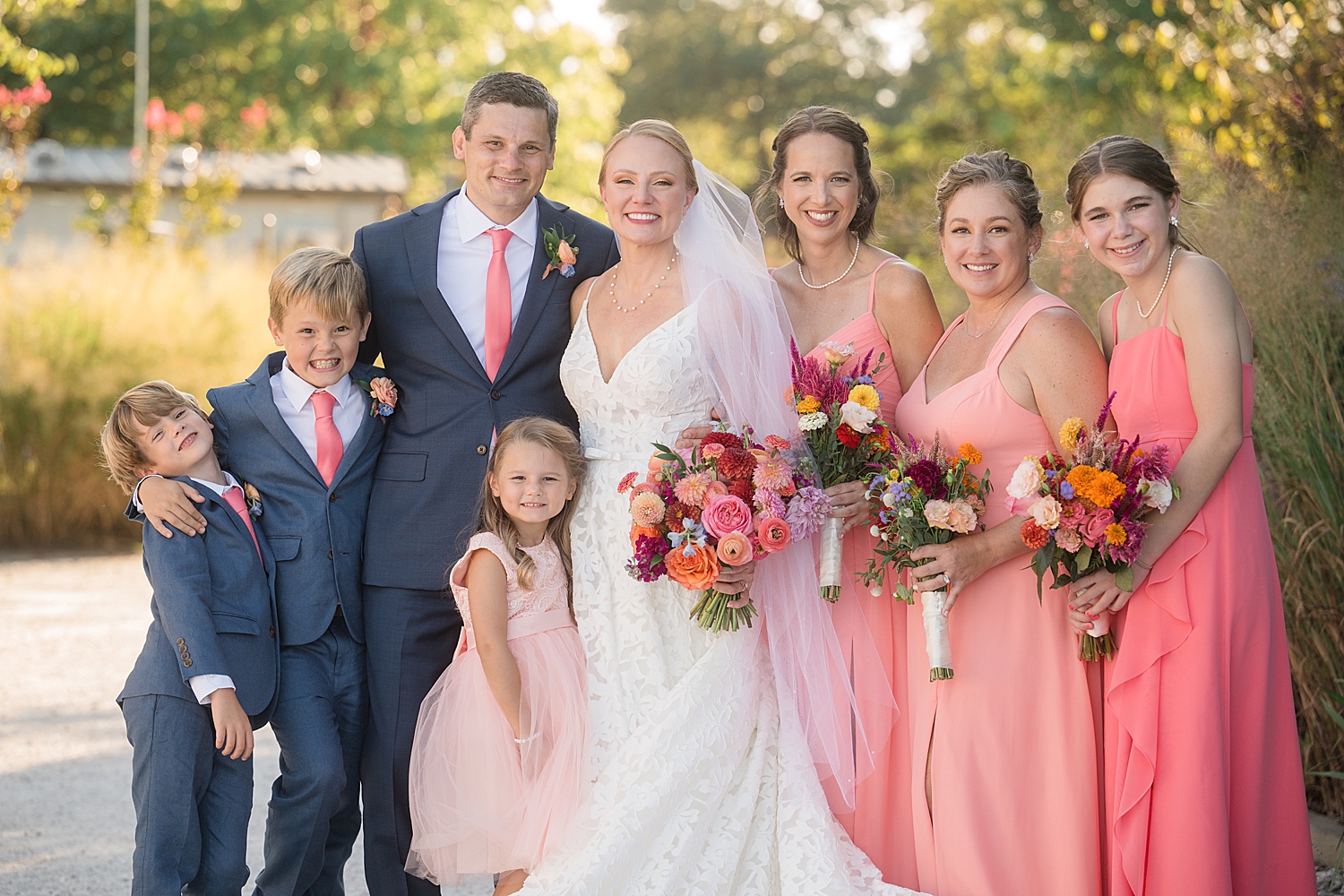 full wedding party portrait, blue suits and pink gowns