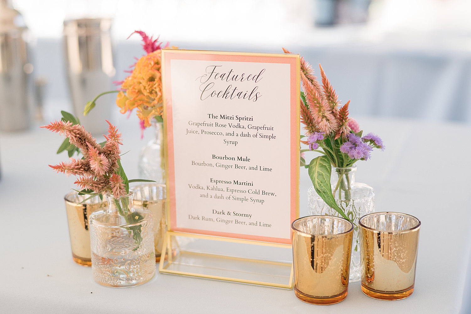 signature cocktail sign with colorful florals and gold votives