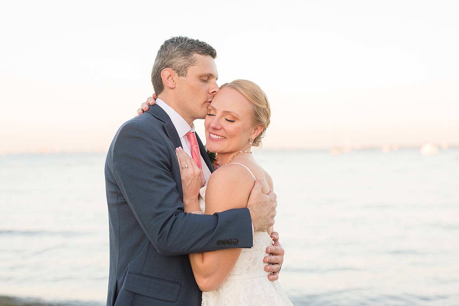 bride and groom embrace at sunset