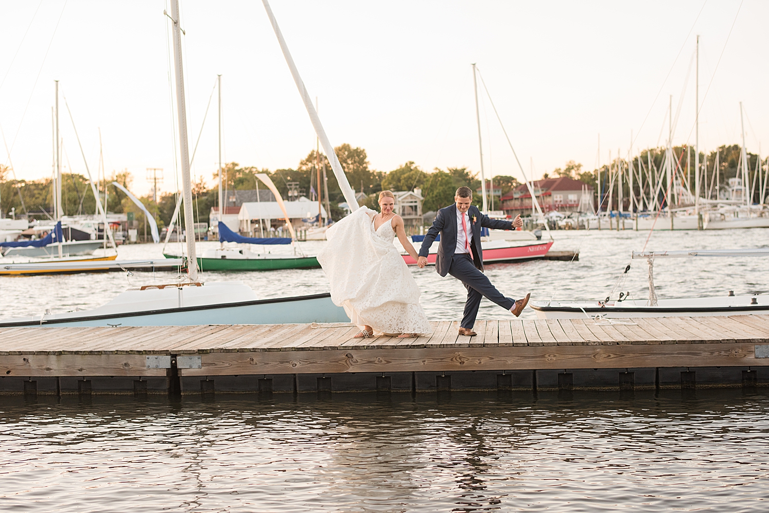 bride and groom share goofy dance on pier