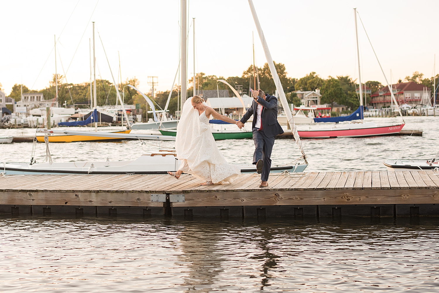 bride and groom share goofy dance on pier