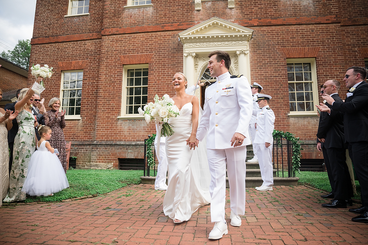 bride and groom laughing with bridal party