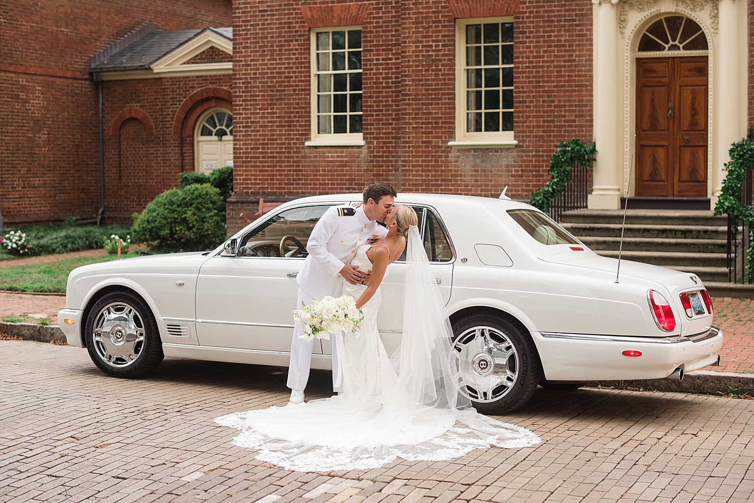 couple dip kiss in front of white limosine