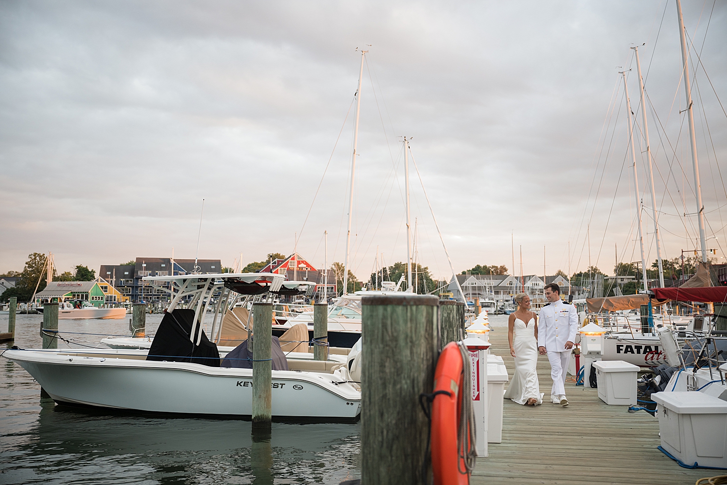 bride and groom on pier at sunset