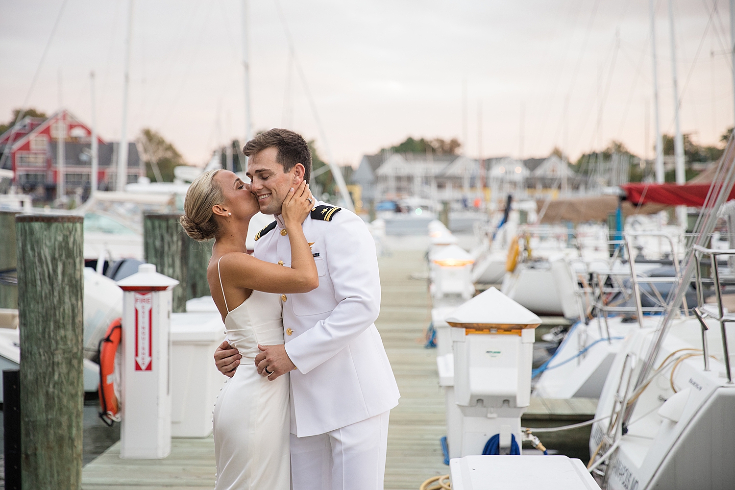 bride and groom on pier at sunset