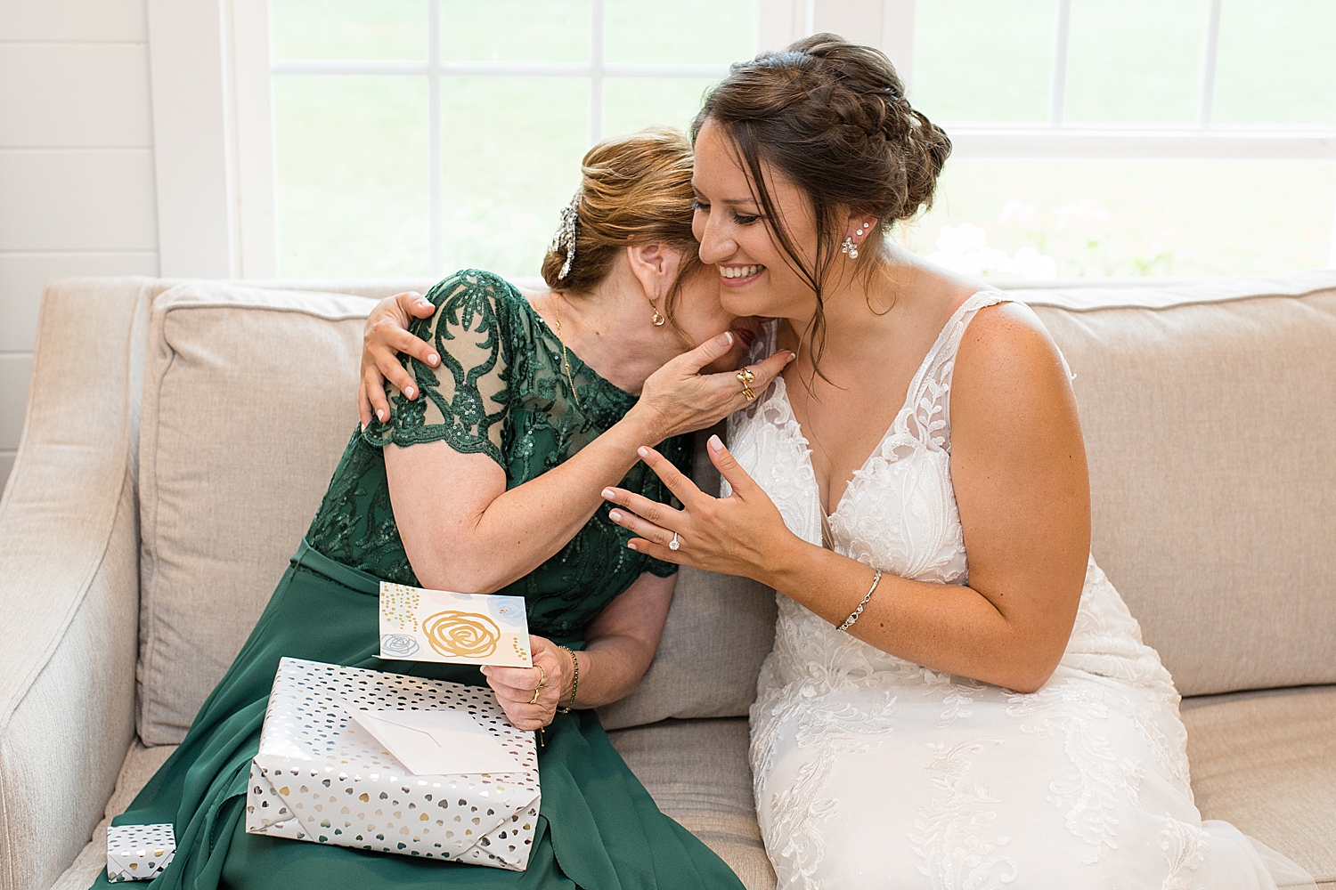 bride's mom embraces bride after opening gift