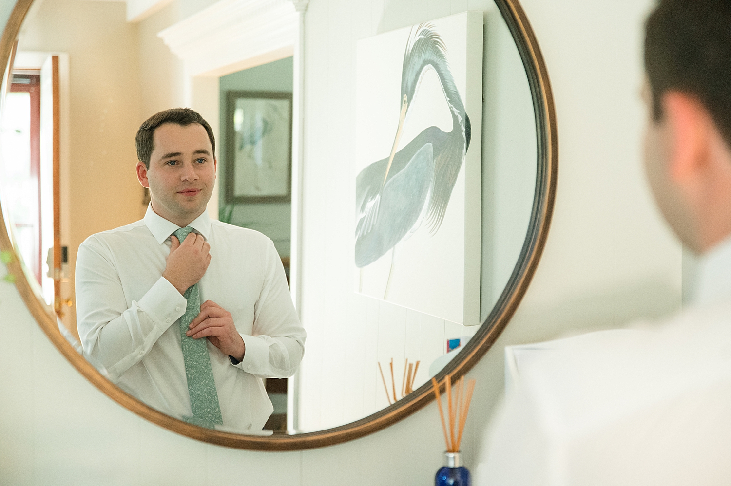 groom getting ready in mirror