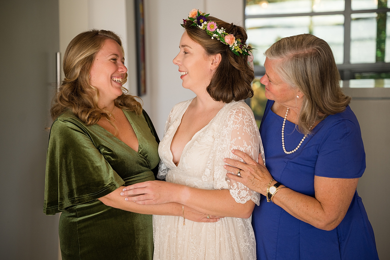 bride getting dressed with mom and sister