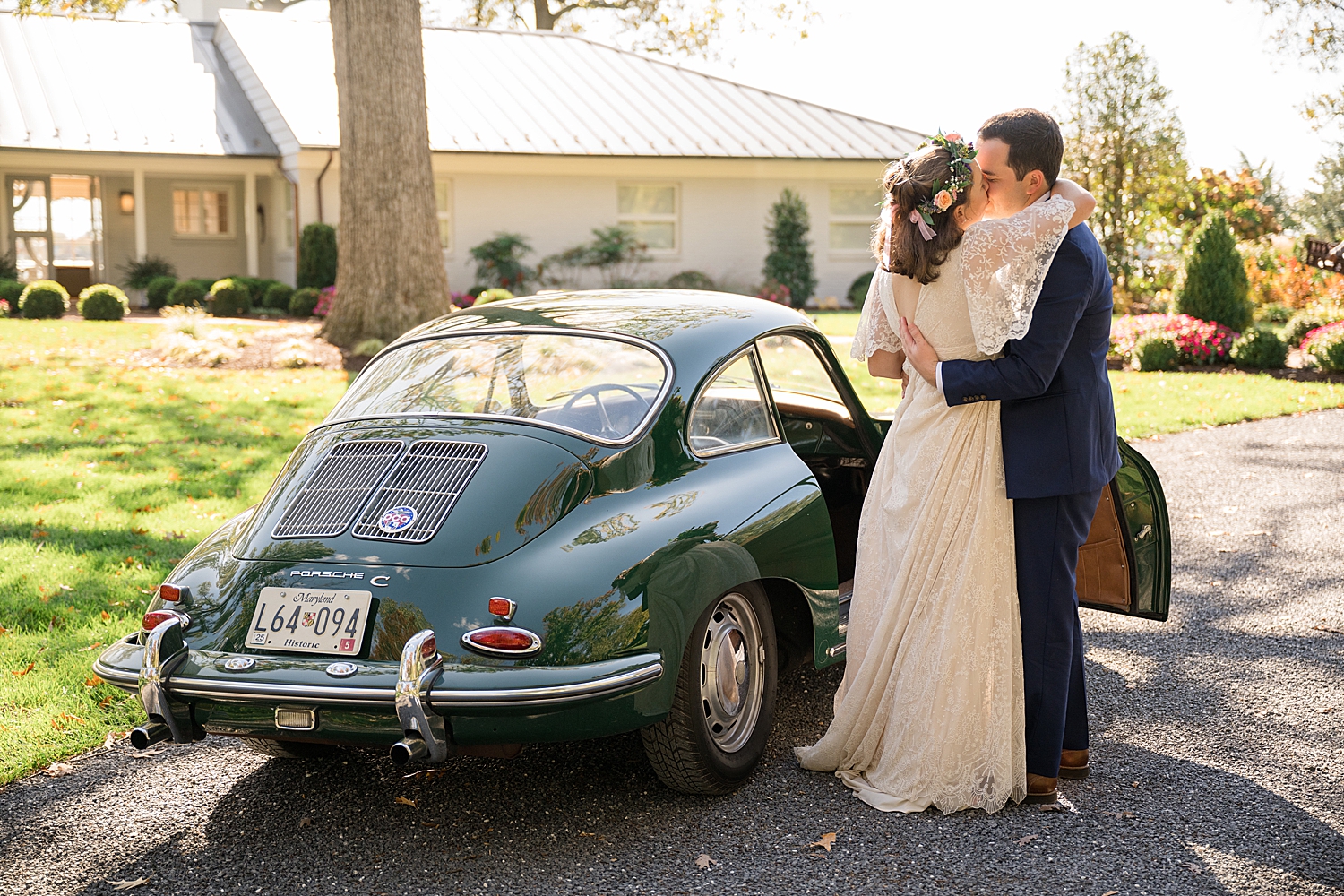 bride and groom kiss in front of green vintage car