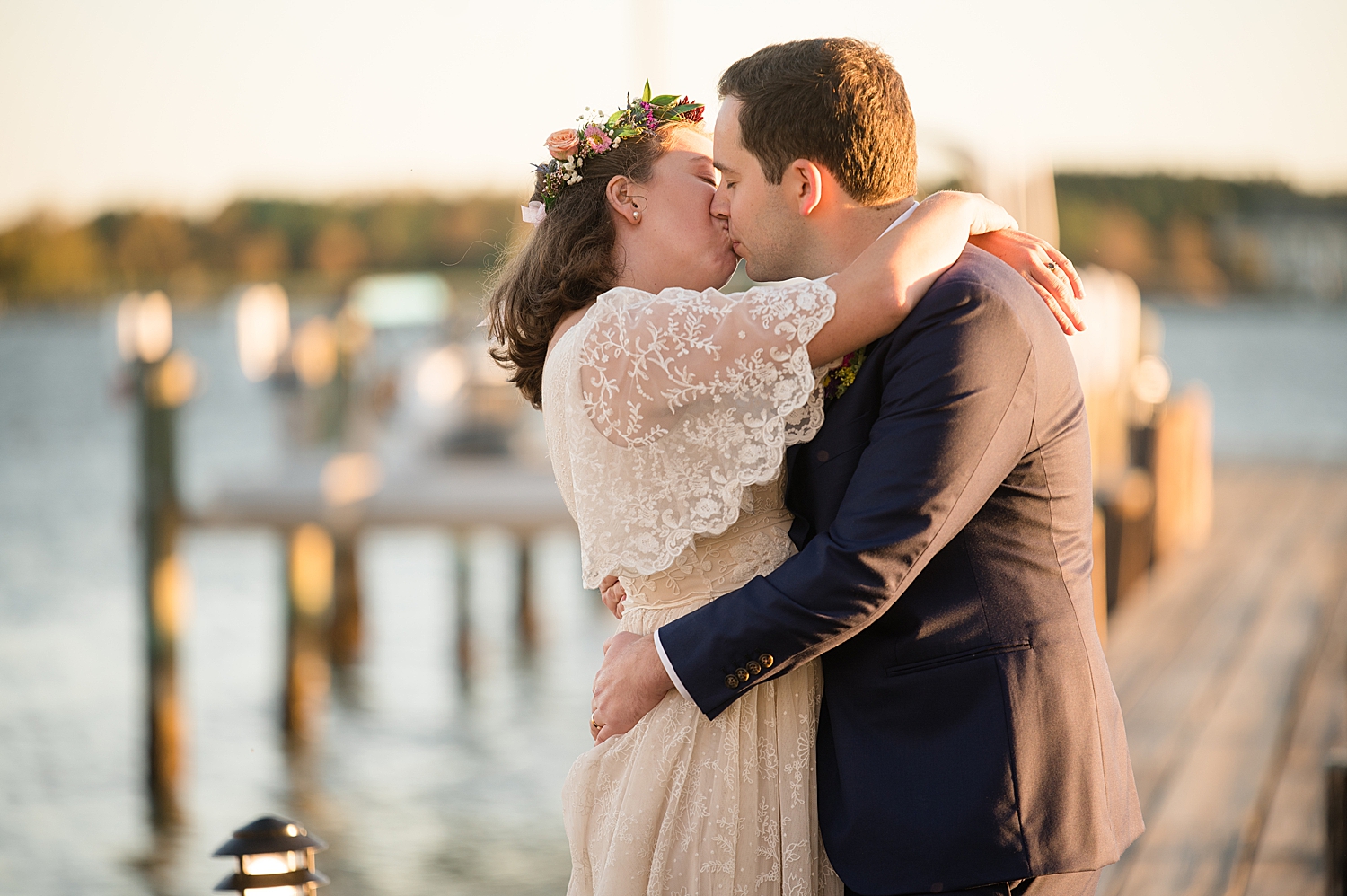 bride and groom kiss on pier