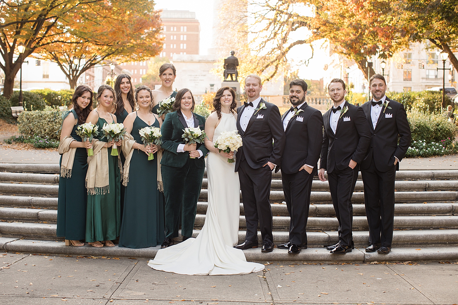 wedding party in black suits and emerald dresses