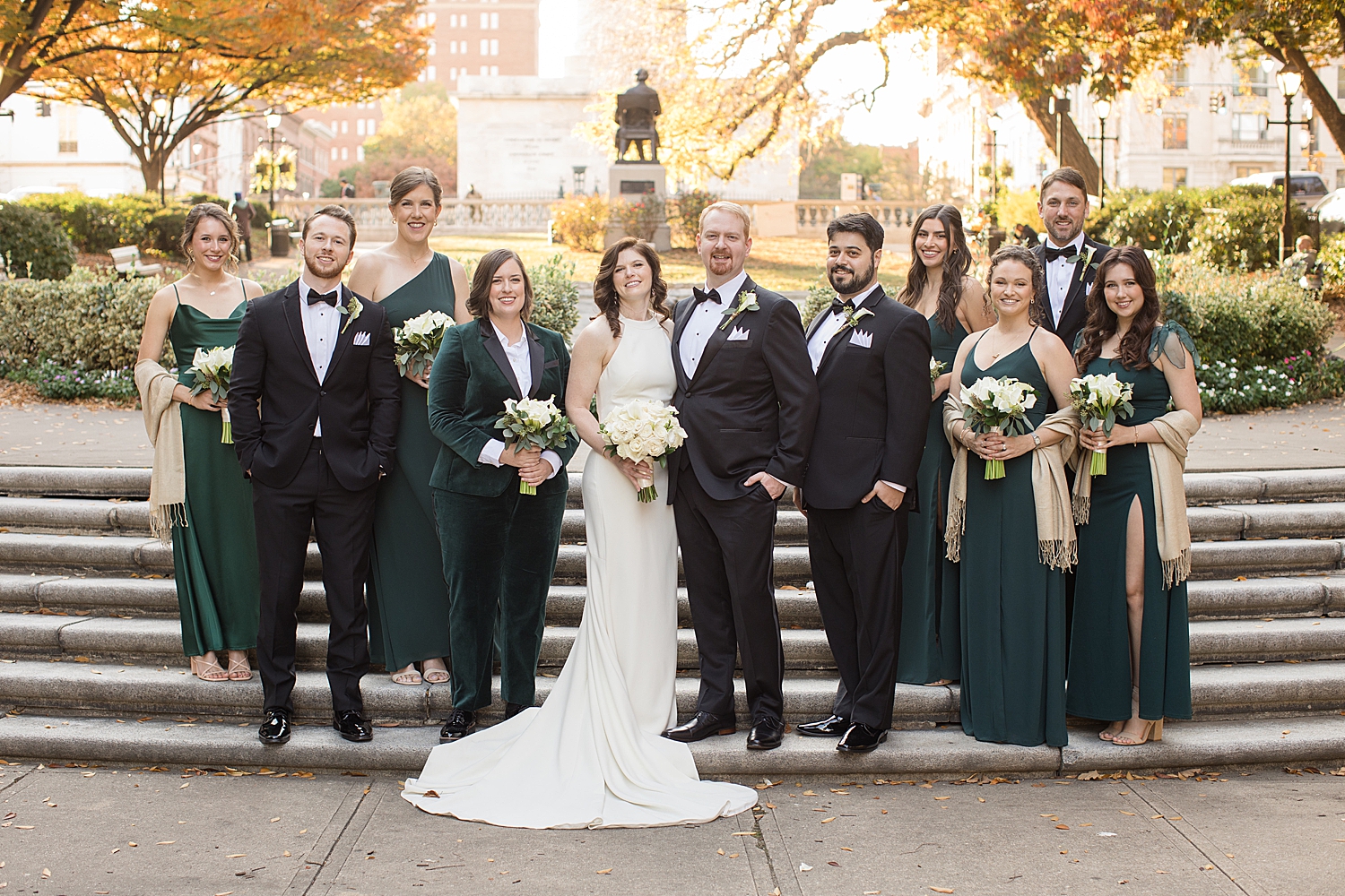 wedding party in black suits and emerald dresses