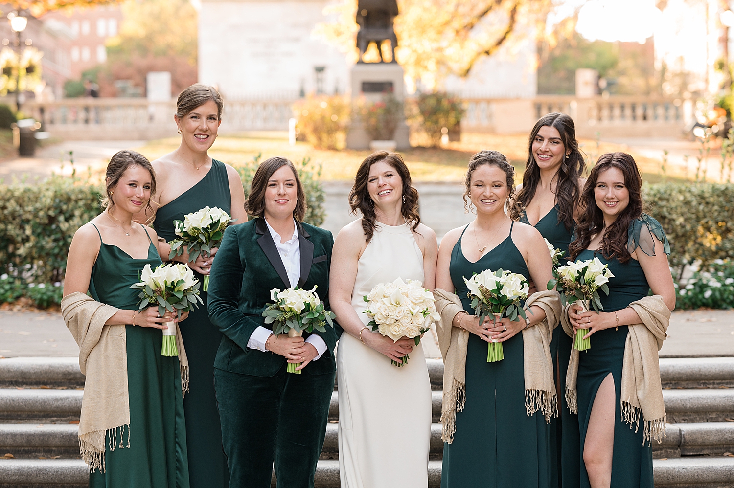 wedding party in black suits and emerald dresses