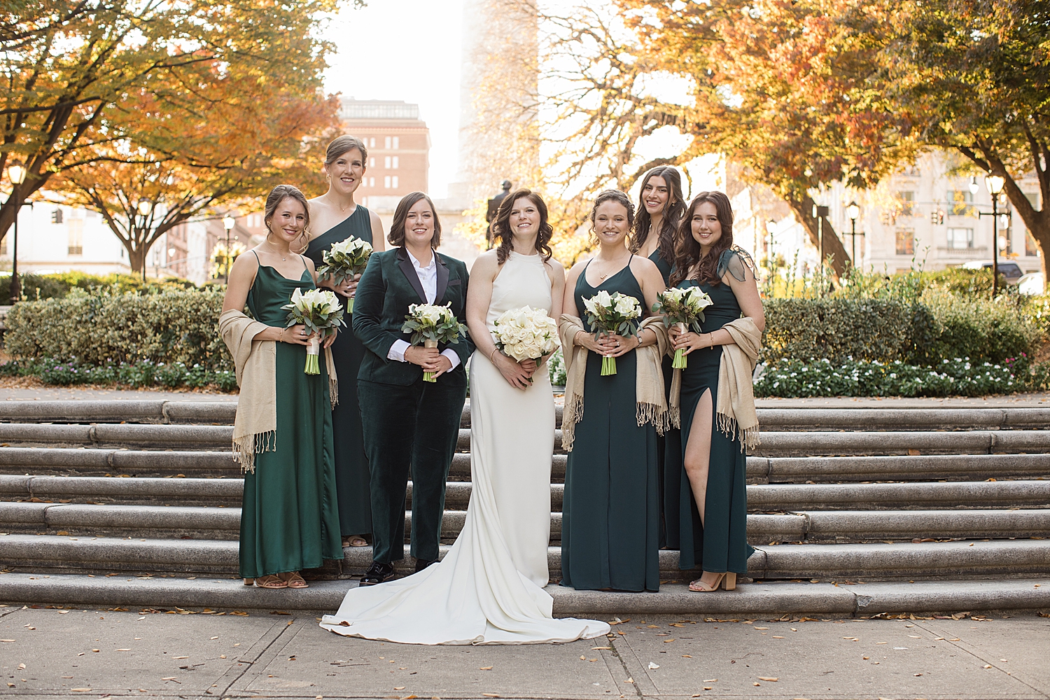 wedding party in black suits and emerald dresses