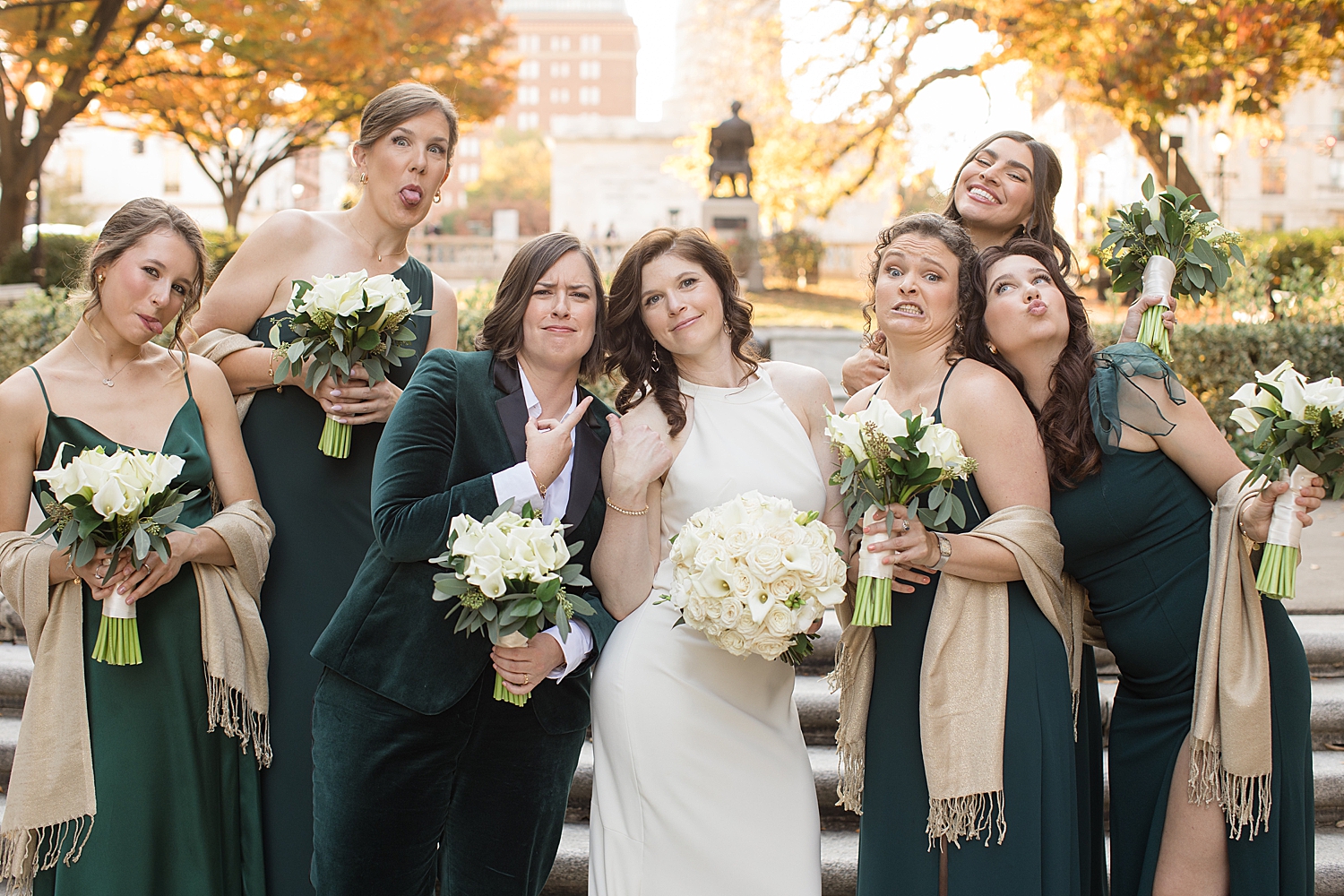 wedding party in black suits and emerald dresses