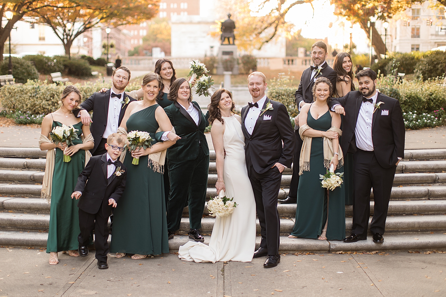 wedding party in black suits and emerald dresses