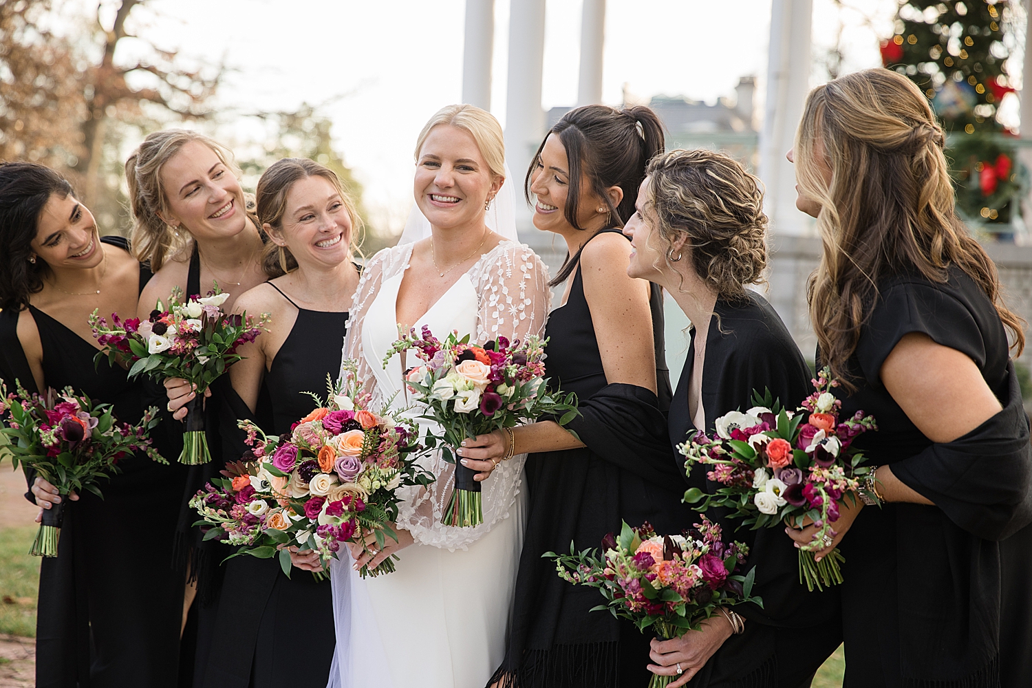 bride with bridesmaids in black velvet dresses and winter florals