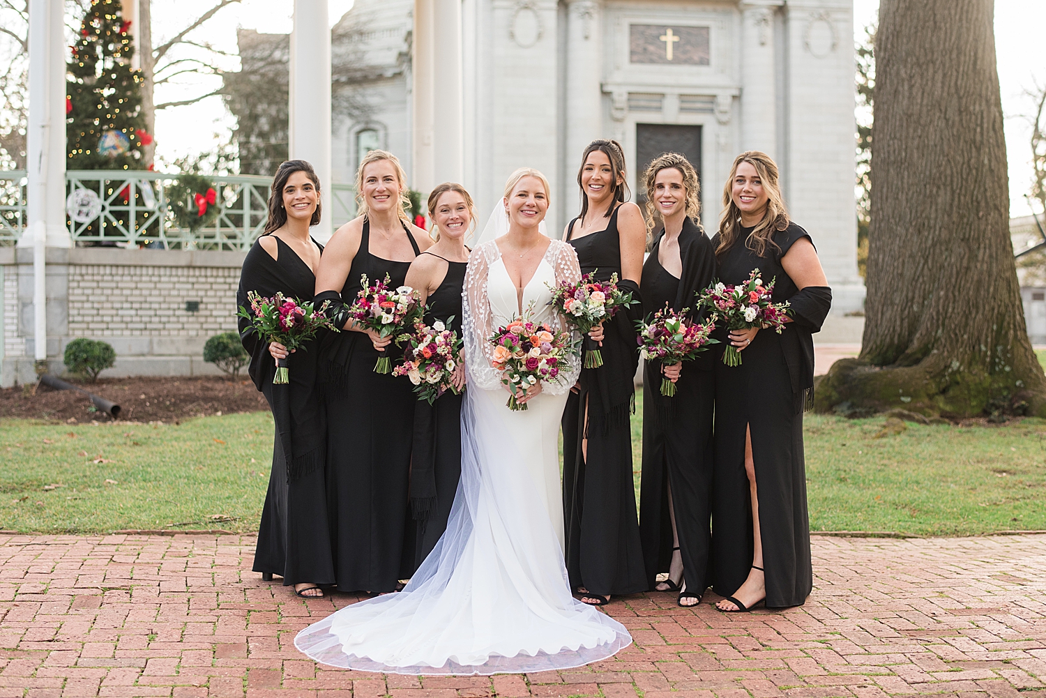 bride with bridesmaids in black velvet dresses and winter florals